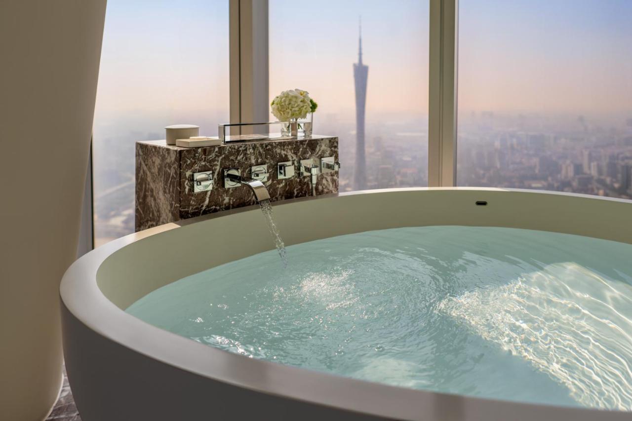 Kamer met kingsize bed, bad aan het raam en uitzicht op de Canton Tower